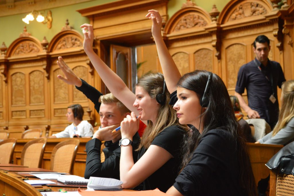 Jugendliche stimmen im Nationalratssaal per Handzeichen ab.